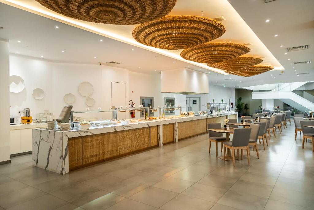 Mūsdienīgs restorāns ar plašu bufeti un elegantu interjeru, kurā ir siltas krāsas un rotājumi no dabīgiem materiāliem. Gaismas elementi rada patīkamu atmosfēru ēdamzālē.