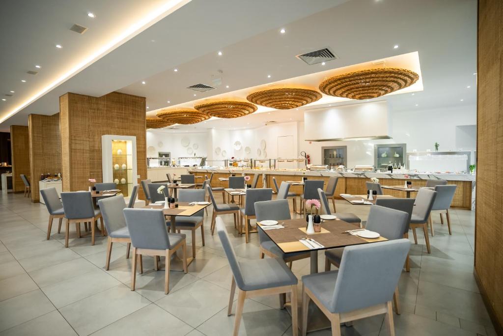 Mūsdienīgs restorāns ar gaišu interjeru un elegantām koka mēbelēm, kas rada patīkamu atmosfēru. Gaismas un dekoratīvie elementi piešķir telpai siltumu un komfortu.