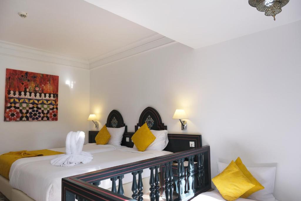 Elegants viesnīcas numurs ar divām gultām, kas dekorēts ar spilgtiem dzelteniem spilveniem un mākslas darbu uz sienas. Numurā ir mūsdienīgi gaismas avoti un estētiski pievilcīgs interjers.