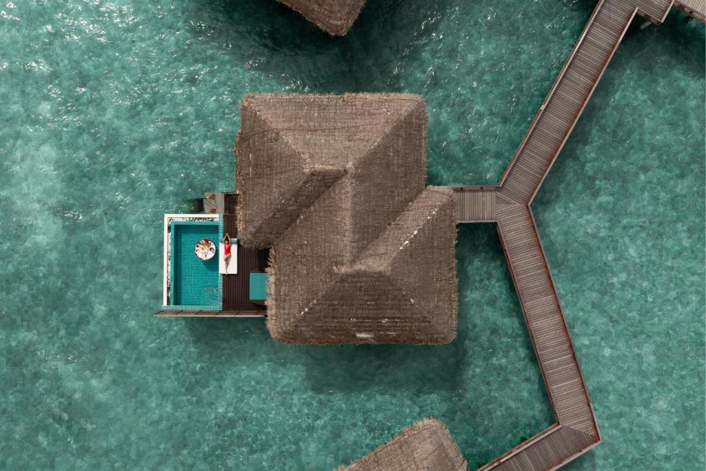 Vasaras māja virs ūdens ar privātu baseinu un terasi, ieskauta skaidrā, zilā ūdenī. Ideāla vieta atpūtai un relaksācijai.