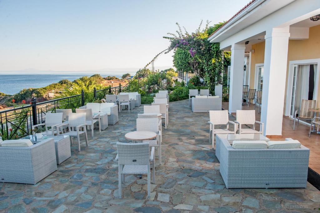 Terases zona ar baltām mēbelēm, kas piedāvā skatu uz jūru un apkārtējām ainavām. Ideāla vieta atpūtai un relaksācijai.