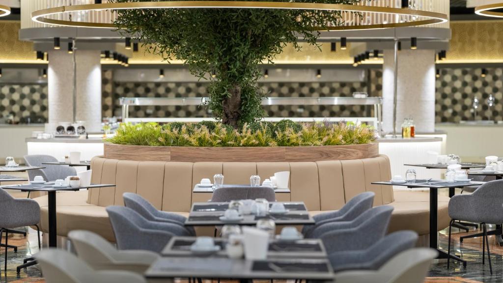 Mūsdienīgs restorāns ar zaļo augu elementu un komfortablu sēdvietu izvietojumu Numa Club Side