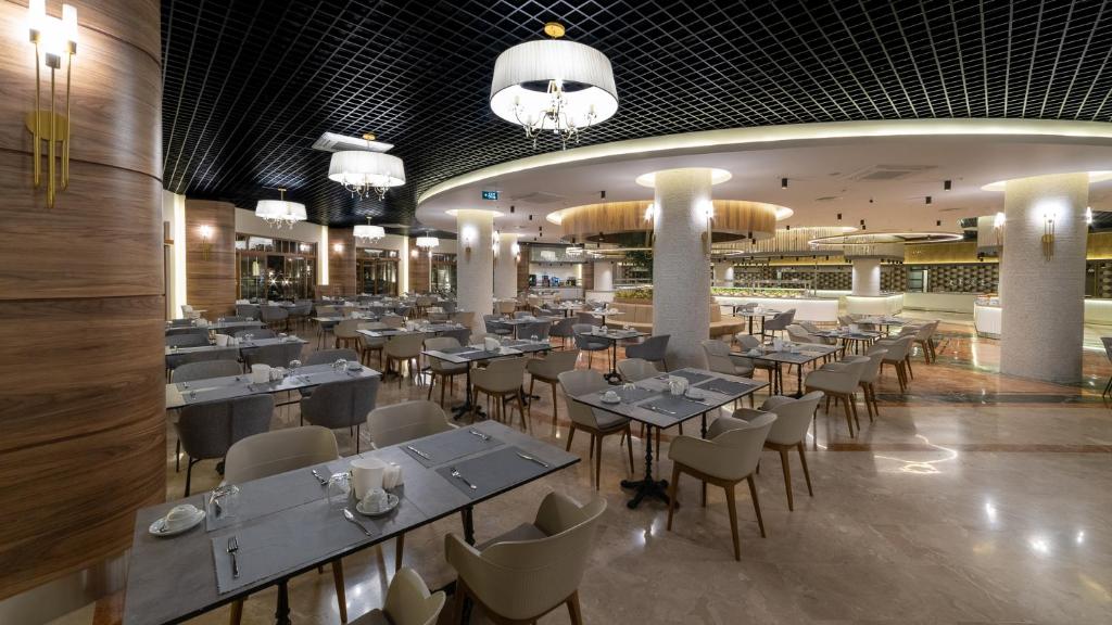 Moderna ēdamzāle Numa Club Side ar elegantiem galdiem un apgaismojumu.