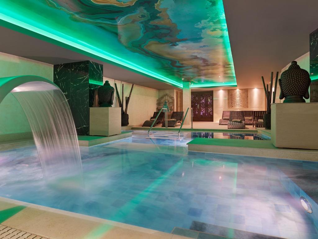 Mūsdienīgs spa ar relaksējošu atmosfēru, zilu peldbaseinu un zaļiem gaismas akcentiem. Ideāla vieta atpūtai un labsajūtai.