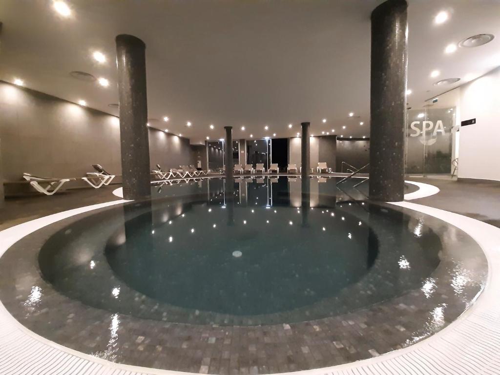Mūsdienīgs spa ar apaļu baseinu, apgaismojumu un atpūtas krēsliem. Ideāla vieta relaksācijai un atjaunošanai.