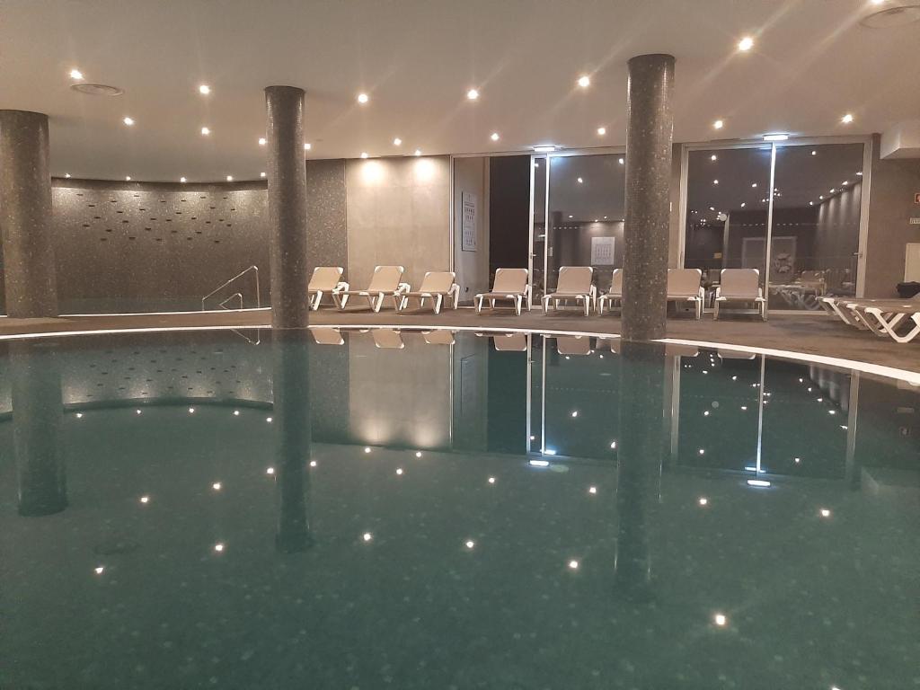 Mūsdienīgs iekštelpu baseins ar apgaismojumu un atpūtas krēsliem, kas atspoguļojas ūdenī. Ideāla vieta relaksācijai un atpūtai.