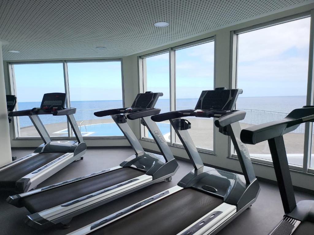 Mūsdienīgas skrejceļu mašīnas sporta zālē ar skatu uz jūru un debesskrāpjiem. Ideāla vide aktīvai atpūtai un treniņiem.