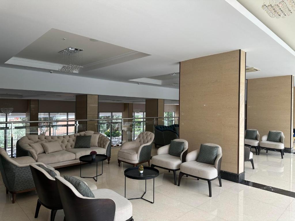 Mūsdienīgs viesnīcas vestibils ar komfortablām mēbelēm un elegantu interjeru, kas rada relaksējošu atmosfēru. Gaismas elementi un lielie logi piešķir telpai dabīgu apgaismojumu.