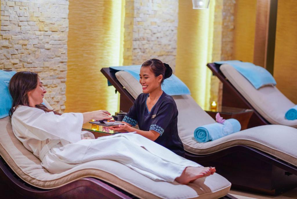 Spa procedūra relaksējošā vidē, kur kliente saņem apkalpošanu no darbinieka, kamēr guļ uz ērtas atpūtas gultas.
