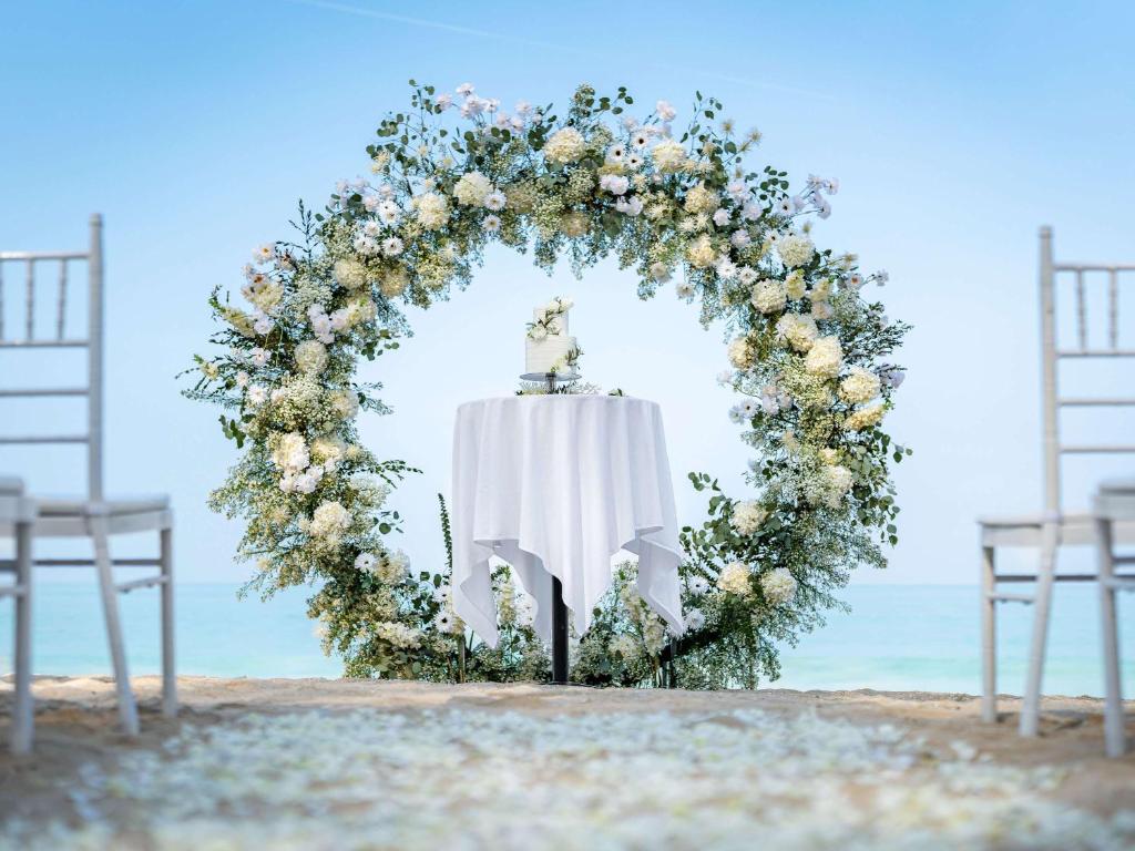 Kāzu ceremonijas vieta piekrastē Grand Mercure Khao Lak Bangsak, rotāta ar ziediem.