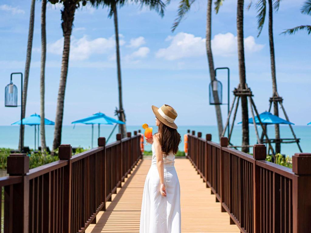 Sieviete staigā pa koka tiltu pie Grand Mercure Khao Lak Bangsak