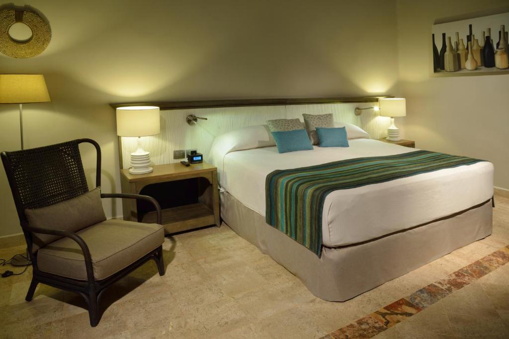 Mūsdienīgs viesnīcas numurs ar dubulto gultu, elegantu apgaismojumu un komfortablu atpūtas krēslu. Interjers veidots mierīgās, neitrālās krāsās, radot relaksējošu atmosfēru.