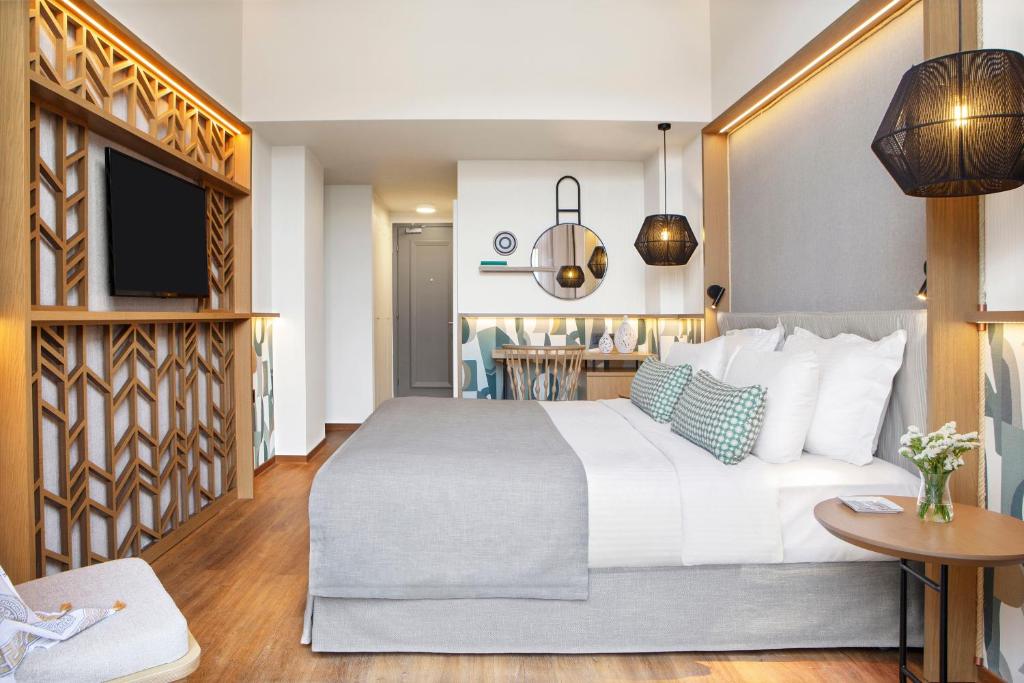 Mūsdienīgs numurs Mirabello Bay Luxury Resort ar elegantu interjeru un ērtu gultu.