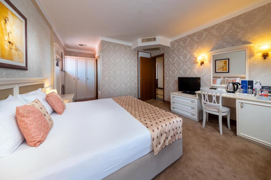 Mūsdienīgs viesnīcas numurs ar ērtu gultu, modernu rakstāmgaldu un televizoru, rotāts ar elegantām detaļām un siltām krāsām. Ideāli piemērots atpūtai un darba aktivitātēm.