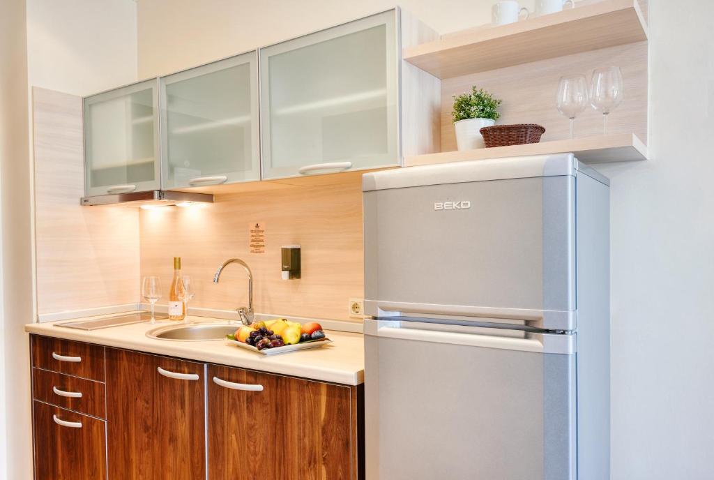 Mūsdienīga virtuve ar koka un stikla elementiem, kurā ir jautra augļu plāksne, izsmalcināta vīna pudele un eleganti trauki.