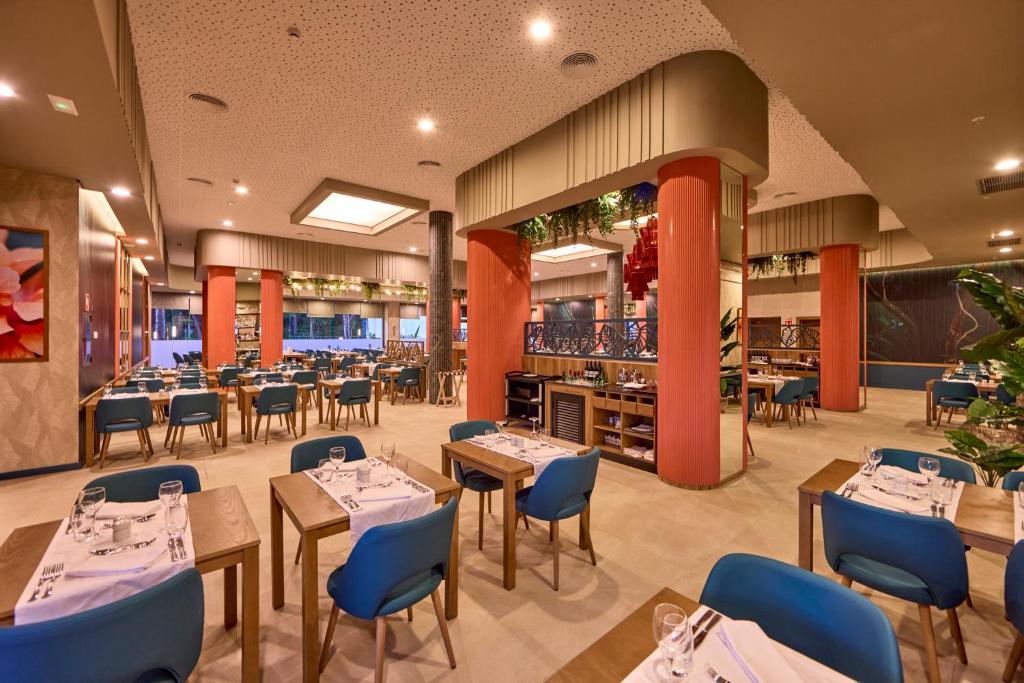 Mūsdienīgs restorāns ar stilīgiem galdiem un krēsliem, kas izceļas ar siltām krāsām un augu dekoriem. Plašs interjers ar mājīgu atmosfēru, ideāls vieta maltīšu baudīšanai.