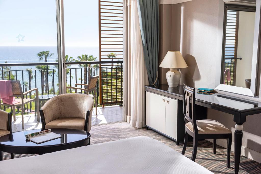 Grezns viesnīcas numurs ar skatu uz okeānu, iekārtots ar ērtām mēbelēm, darba galdu un balkonu ar palmām. Ideāla vieta relaksācijai un atpūtai.