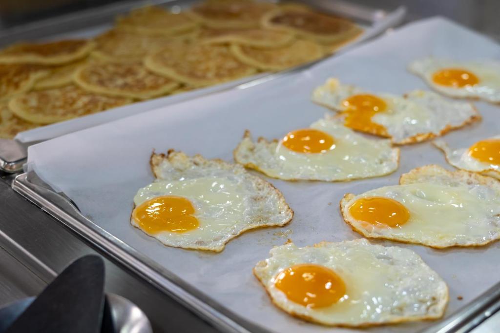 Ceptas olas ar dzeltenumiem uz paplātes, blakus pankūkām. Svaiga un garšīga brokastu izvēle.