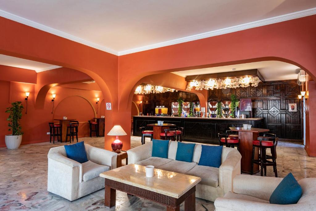 Mūsdienīgs viesnīcas bārs ar siltām krāsām un komfortablām mēbelēm, ideāla vieta relaksācijai un sociālai mijiedarbībai. Gaismas un dekorācijas piešķir patīkamu atmosfēru.