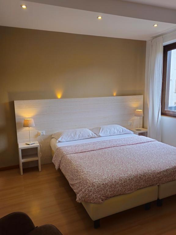 Mūsdienīga guļamistaba ar divguļamo gultu, mēbelēm un gaismas avotiem. Logā ieplūst dabiska gaisma, radot siltu un mājīgu atmosfēru.