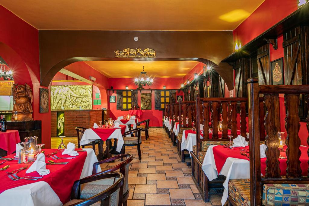 Sarkans interjers ar elegantām galdiem un izsmalcinātu apgaismojumu, izveidojot patīkamu atmosfēru restorānā. Dekorācijas ietver skulptūras un mākslas darbus, kas piešķir telpai unikālu šarmu.