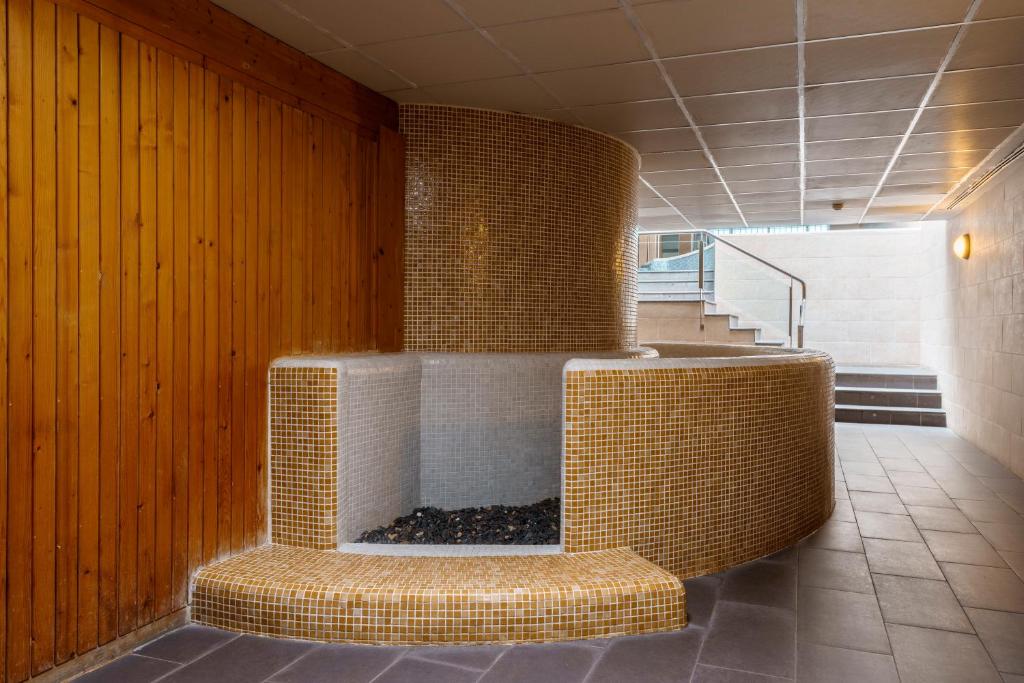 Mūsdienīgs un stilīgs spa stūrītis ar apaļu akmens mozaīkas dizainu un koka apdari, kas rada relaksējošu atmosfēru. Ideāla vieta atpūtai un relaksācijai.