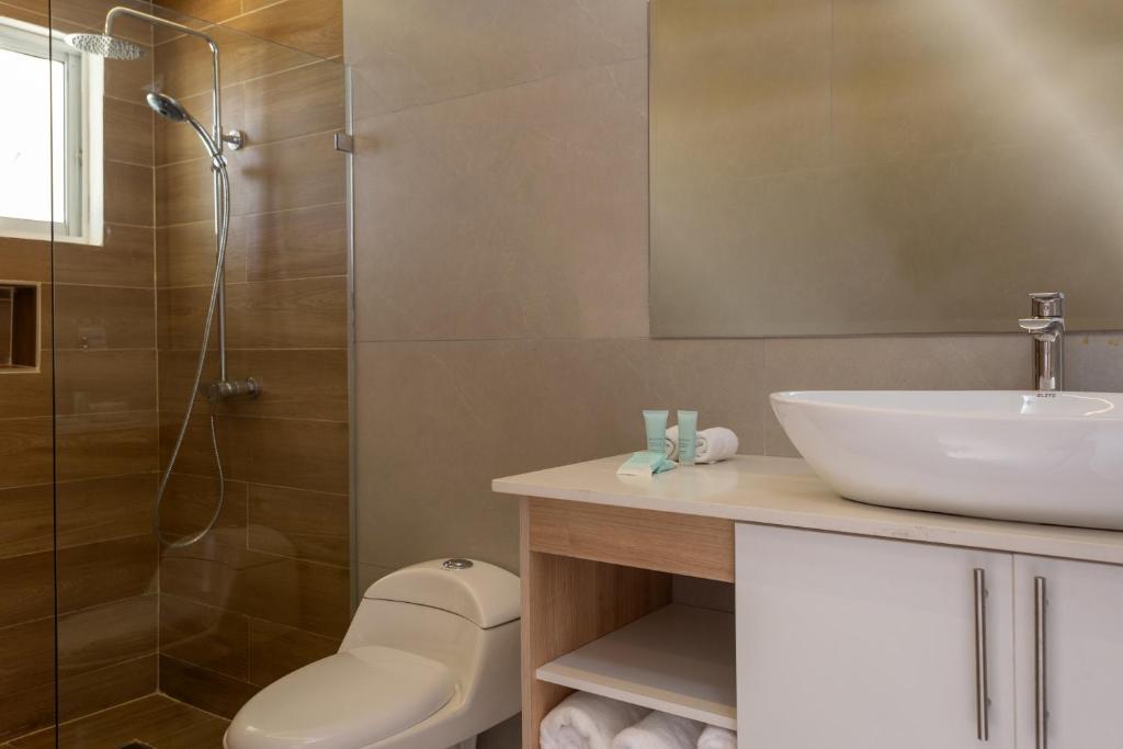 Mūsdienīgs vannas istabas interjers ar stikla dušu un modernu izlietni, kas papildināta ar vannas piederumiem un dvieļiem.