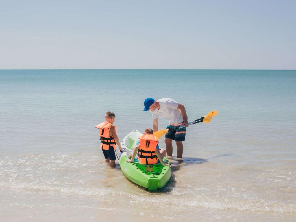 Bērni ar pieaugušo, kas gatavojas izklaidei piekrastē Grand Mercure Khao Lak Bangsak