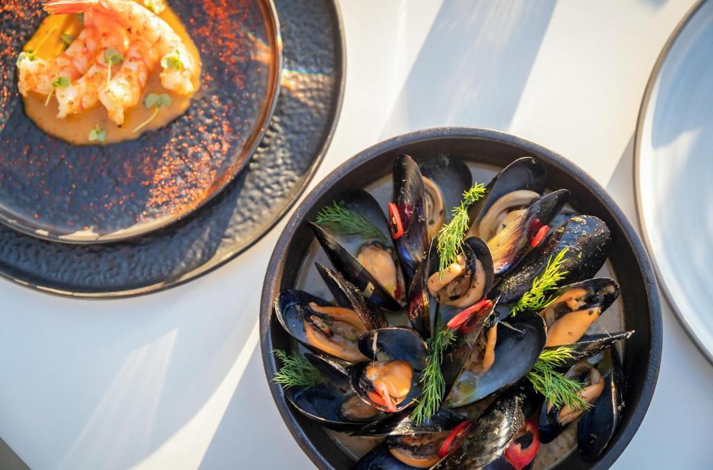 Svaigu jūras velšu platīte ar mīdijām un garnelēm, dekorēta ar dilles un sarkano čili. Pievienotie garnelēm ir pasniegti uz krēmīgas mērces.