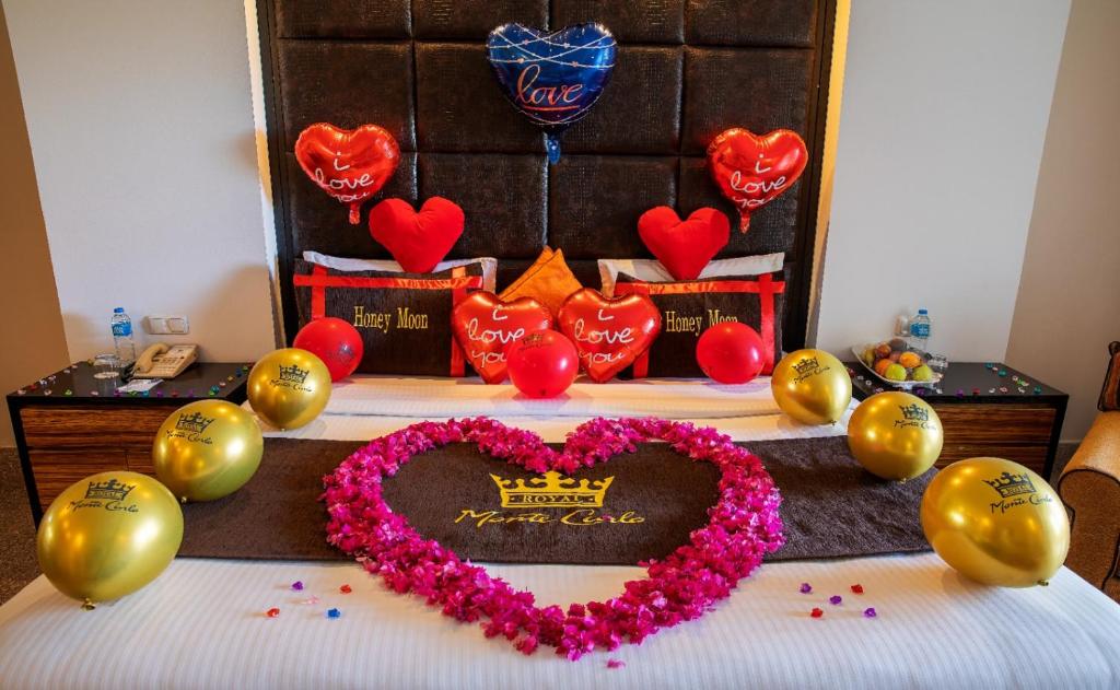 Romantiska viesnīcas istaba ar sirds formas ziedu kompozīciju, sarkaniem un zelta baloniem, kā arī dekoratīvām spilvenu uzrakstiem "I love you" un "Honey Moon". Ideāla vide svinībām un romantiskām brīvdienām.