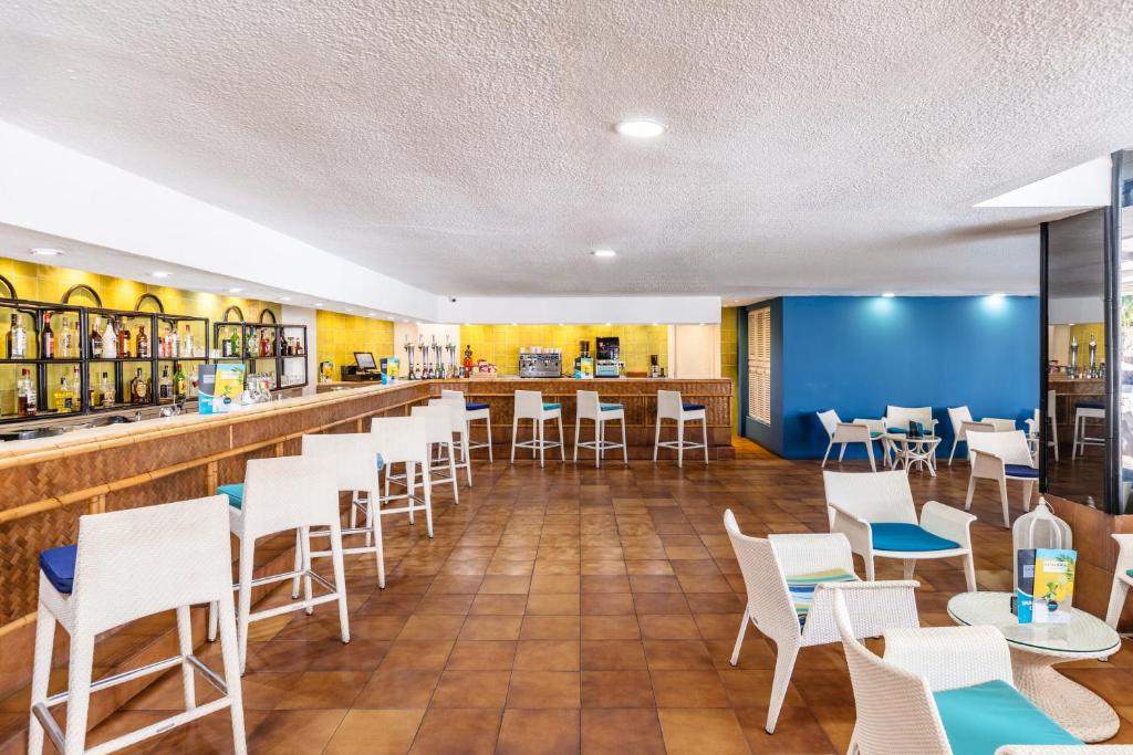 Mūsdienīgs bārs ar gaišu interjeru, kurā ir eleganti sēdekļi un plaša dzērienu izvēle. Ideāla vieta relaksācijai un socializēšanai.