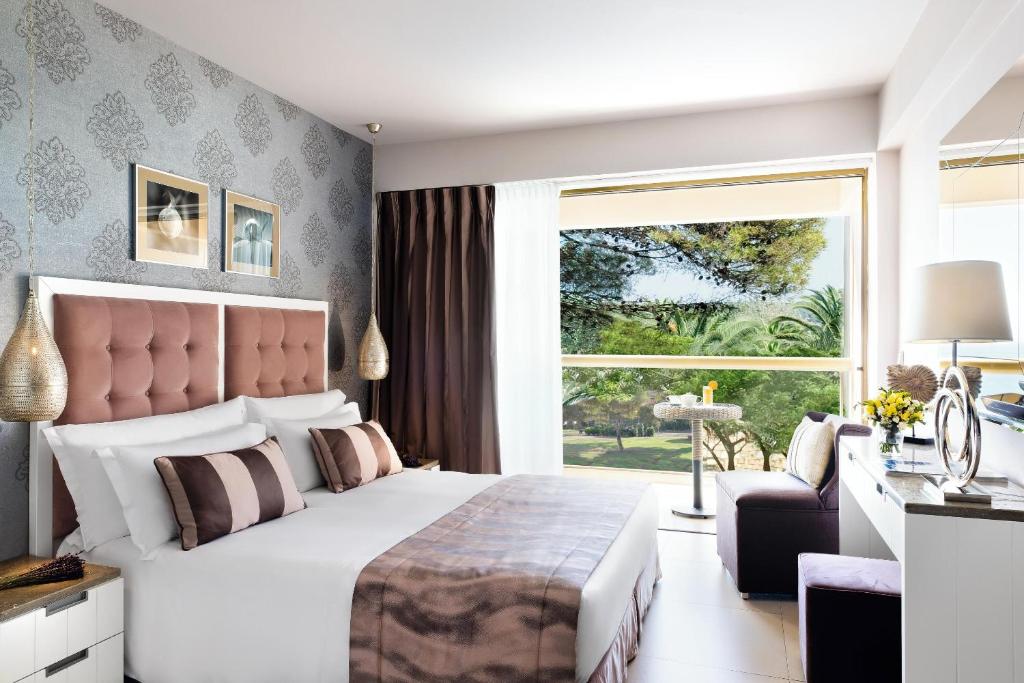 Mūsdienīga guļamistaba ar elegantu interjeru, kas ietver mīkstus gultas veļas toņus un plašu logu ar skatu uz dārzu. Iekārtota ar mākslas darbiem un stilīgām mēbelēm, tā nodrošina komfortablu un relaksējošu atmosfēru.