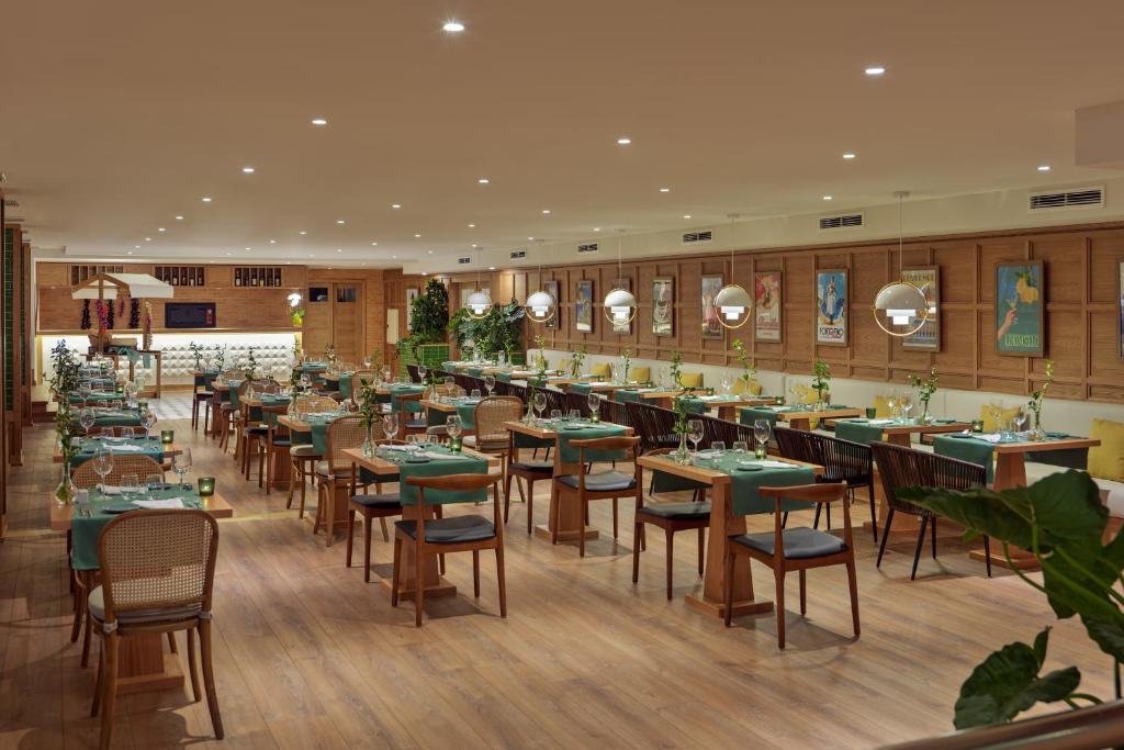 Moderns restorāns ar elegantiem galdiem un krēsliem, zaļiem galdautiem un dekoratīviem elementiem. Interjers ir gaišs un viesmīlīgs, radot patīkamu atmosfēru maltītēm.