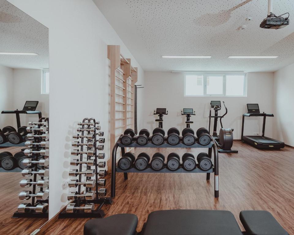 Moderns sporta zāles interjers ar svaru stendiem, skrejceliņiem un citiem fitnesa aprīkojumiem. Telpa ir gaiša un plaša, nodrošinot ideālu vidi treniņiem.