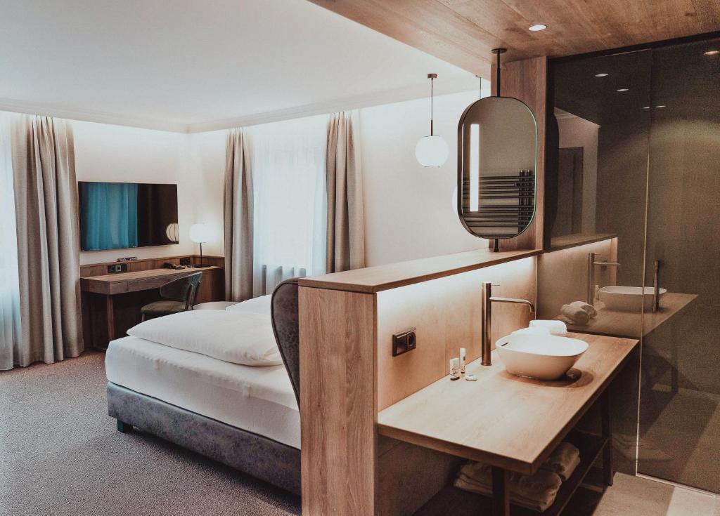 Mūsdienīgs viesnīcas numurs ar ērtu gultu, darba galdu un modernu vannas istabu. Interjers ir gaišs un elegants, radot relaksējošu atmosfēru.