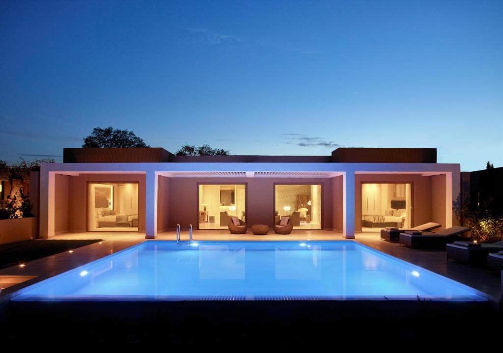 Mūsdienīga villa ar baseinu, kas apgaismota vakara gaismā. Elegants dizains un relaksējoša atmosfēra.