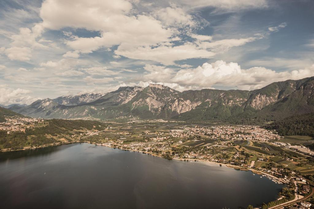 Ainava ar kalniem un ezeru, kas atspoguļo mierīgu lauku vidi un skaistu debesi. Apkārtējās pilsētas un lauksaimniecības zemes papildina ainavu.