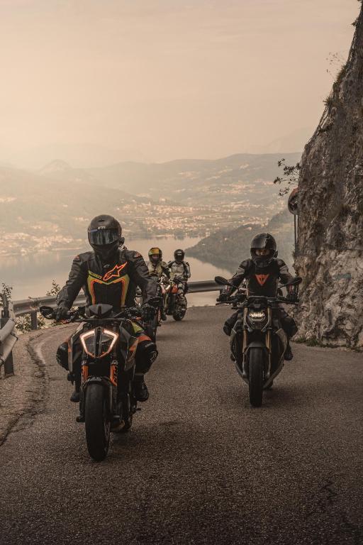 Motociklu grupas brauc pa kalnu ceļu, apgleznojot ainavu ar skaistām kalnu un ūdens ainavām. Rūpīgi aprīkoti braucēji demonstrē adrenalīnu un aizrautību.