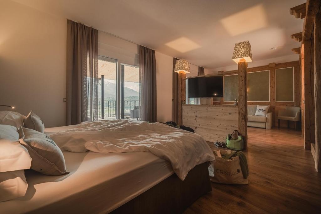 Mūsdienīgs viesnīcas numurs ar ērtu gultu, koka elementiem un plašām logu durvīm, caur kurām paveras skats uz kalniem. Interjers ir siltā krāsu paletē ar mīkstiem apgaismojuma elementiem.