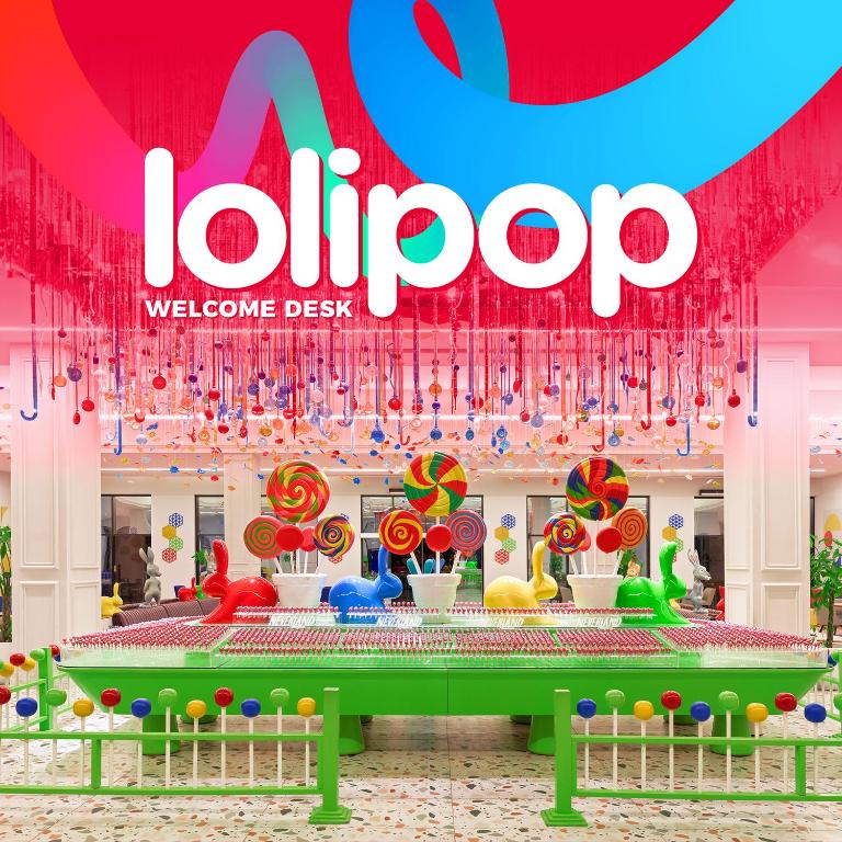 Krāsainais laipni lūdzam galds "Lolipop" ar spilgtām konfektēm un rotaļīgām dekorācijām, veidojot jautru un pievilcīgu atmosfēru.