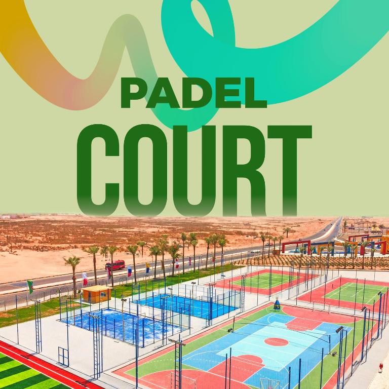 Padel laukums ar vairākiem spēļu laukumiem un skaidru debesi, kas atrodas tuksneša ainavā.
