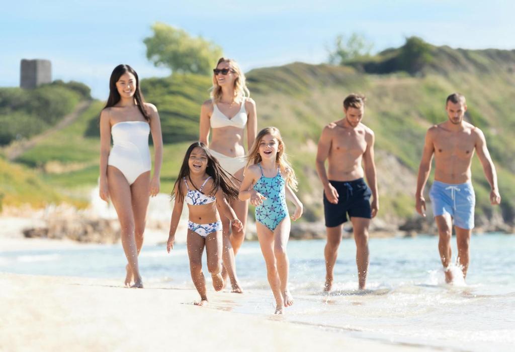 Piedzīvojumu brīvdienas pludmalē ar ģimeni un draugiem, baudot sauli un ūdeni. Jauka atmosfēra ar laimīgiem bērniem un pieaugušajiem, kas pastaigājas gar krastu.