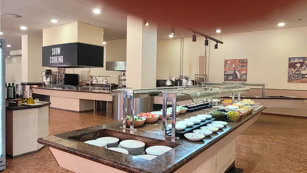 Restorāna bufete ar dažādiem ēdieniem un salātiem, iekārtota ar atvērtu virtuvi un "SHOW COOKING" zonu. Moderns interjers ar plašu telpu un ērtām galdiem.