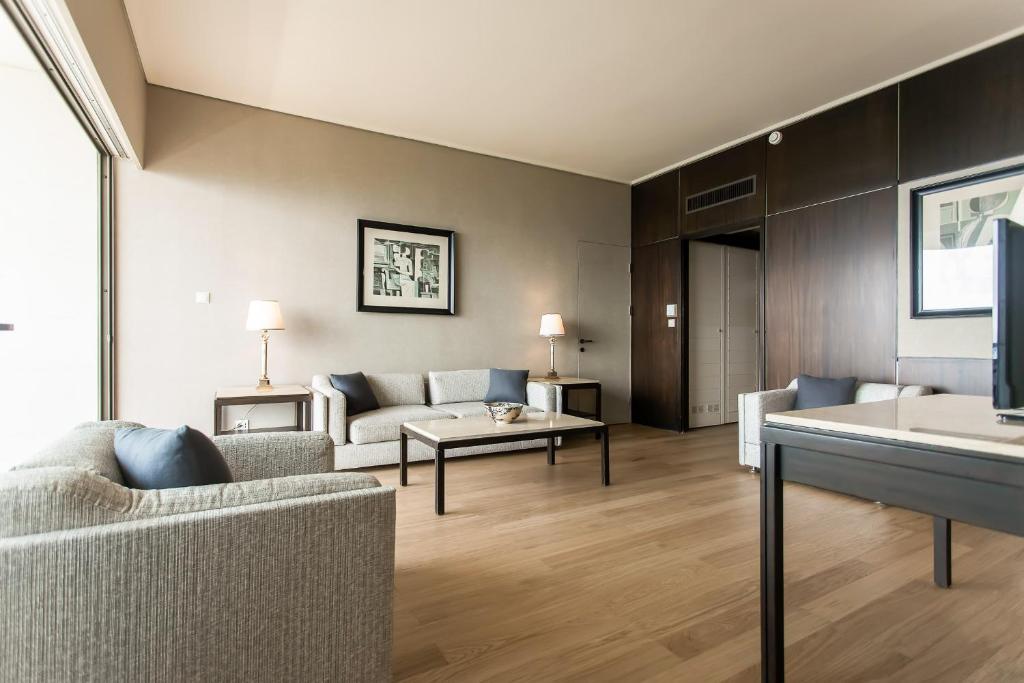 Mūsdienīgs un stilīgs viesistabas interjers ar gaišām krāsām, komfortabliem dīvāniem un ērtu galdu. Telpa ir apgaismota ar lampu, radot patīkamu atmosfēru.