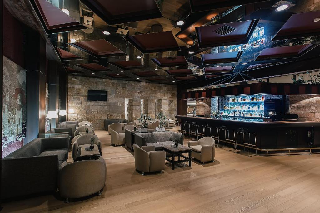 Mūsdienīgs bārs ar elegantiem sēdekļiem, apgaismojumu un akmens sienām, radot patīkamu atmosfēru atpūtai. Bāra plaukts ir piepildīts ar dzērieniem, piedāvājot plašu izvēli.