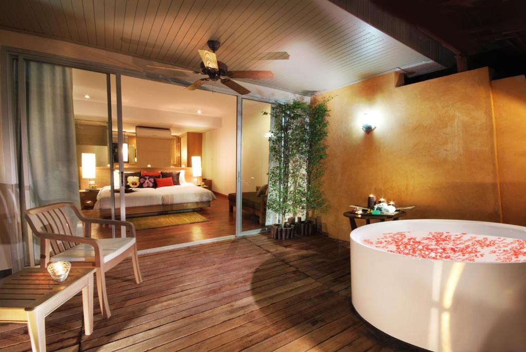 Terase ar romantisku atmosfēru, kurā atrodas liela baļļa ar ziedlapiņām, ērtas mēbeles un skats uz elegantu guļamistabu. Ideāla vieta relaksācijai un atpūtai.