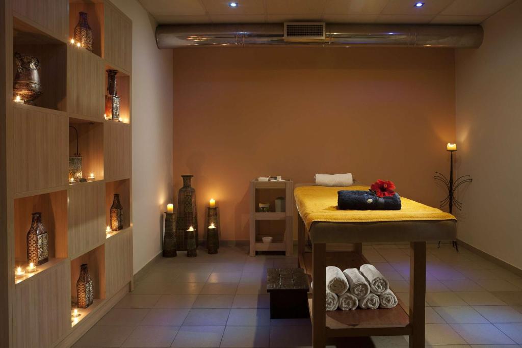 Mierīga spa telpa ar masāžas galdu un sveču apgaismojumu Blue Bay Resort Crete