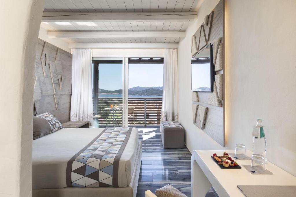 Mūsdienīgs viesnīcas numurs ar skatu uz kalniem, gaišām krāsām un elegantu interjeru. Numurā ir gulta, televizors un neliels galdiņš ar uzkodām.