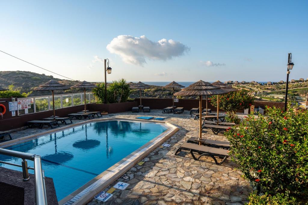 Peldbaseins ar sauļošanās krēsliem pie Blue Bay Resort Crete