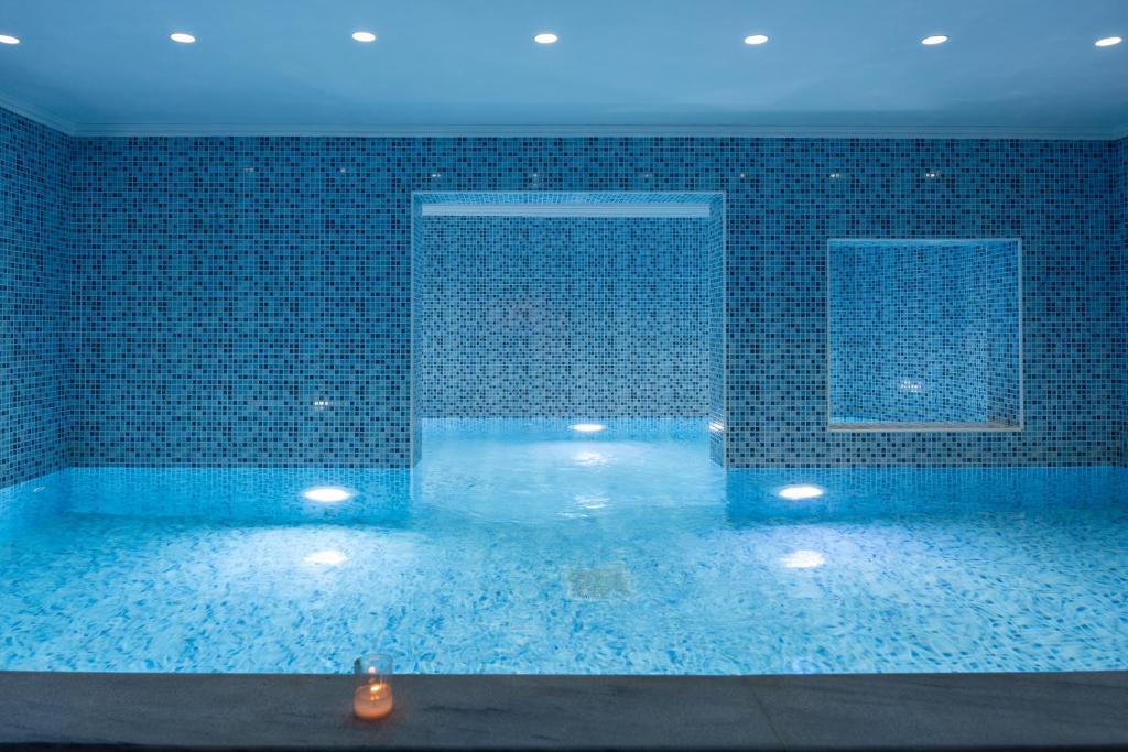 Relaksējoša peldvieta Blue Bay Resort Crete ar mirdzošu ūdeni un mozaīkas flīzēm.